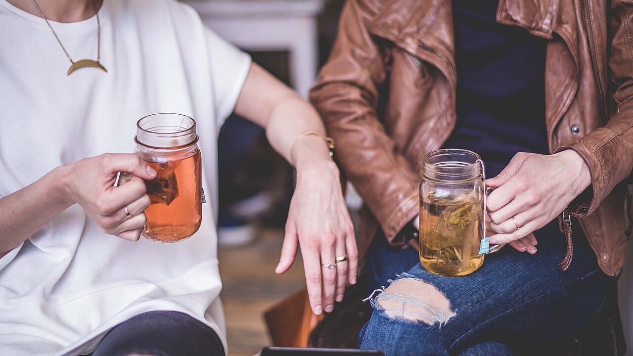 Dos personas conversan con calma mientras toman té